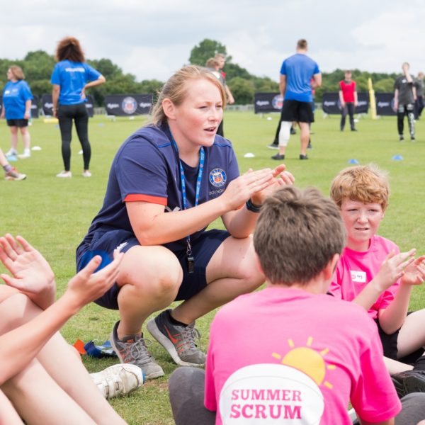 Corporate marketing photography with Bath Rugby Academy coach talking to a group of children at Odd Down Sports Centre in Bath