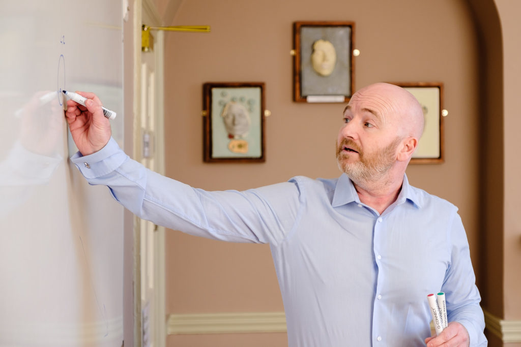 Corporate marketing photography from a series with lecturer writing on a white board