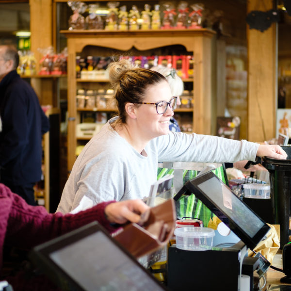 Corporate marketing photography with customer talking to staff on the tills at Allington Farm Shop in Wiltshire
