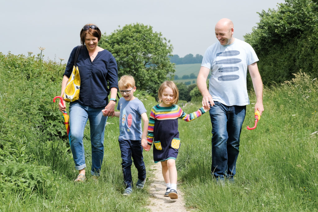 Keri with her family, all holding hands on a country day out in north Wiltshire