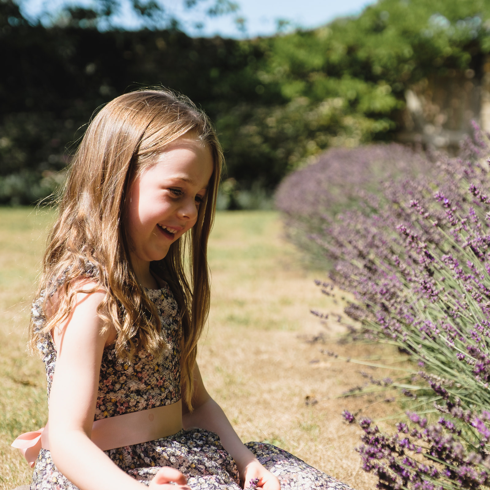 Family holiday photography - young girl in floral dress with lavender at Cotswold county house