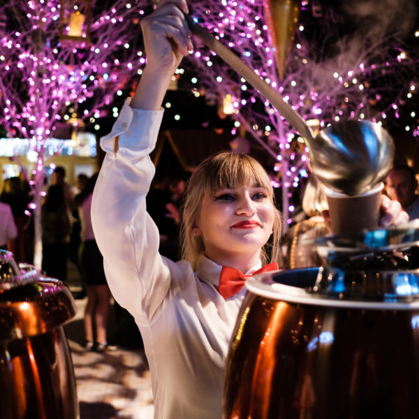 Corporate event photography with Christmas decorations and Waitress serving mulled wine