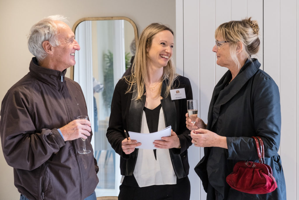 Sales team discussing property details with clients at Bath property launch