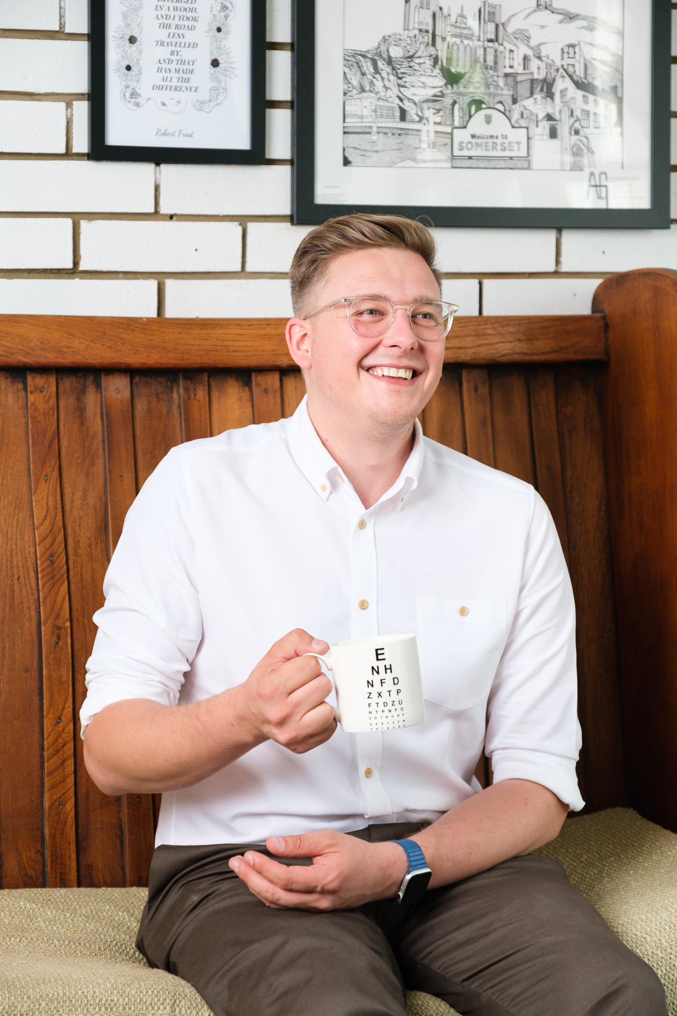 Business photography with male optician relaxed and holding a coffee mug
