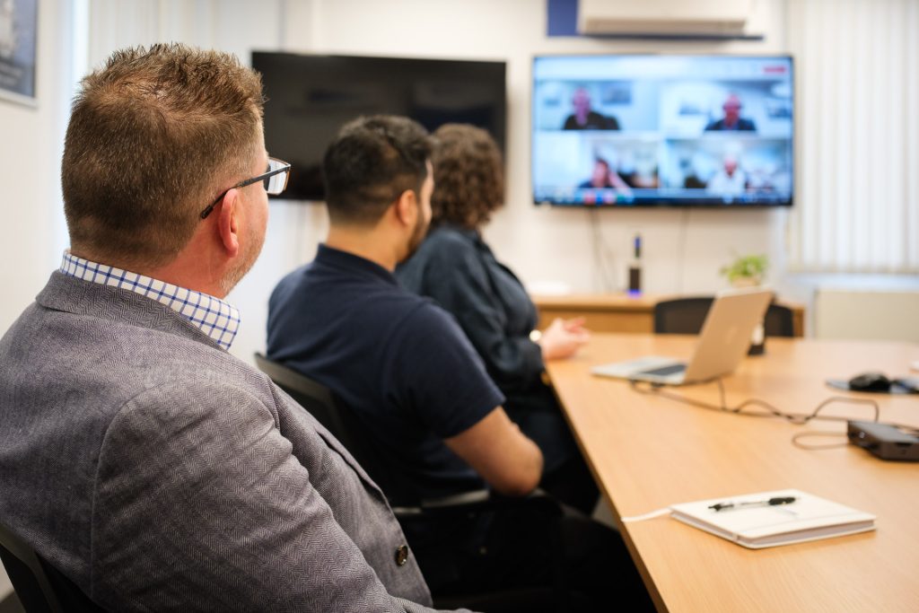Engineering consultants in a project meeting with colleagues dialled in on a Teams call