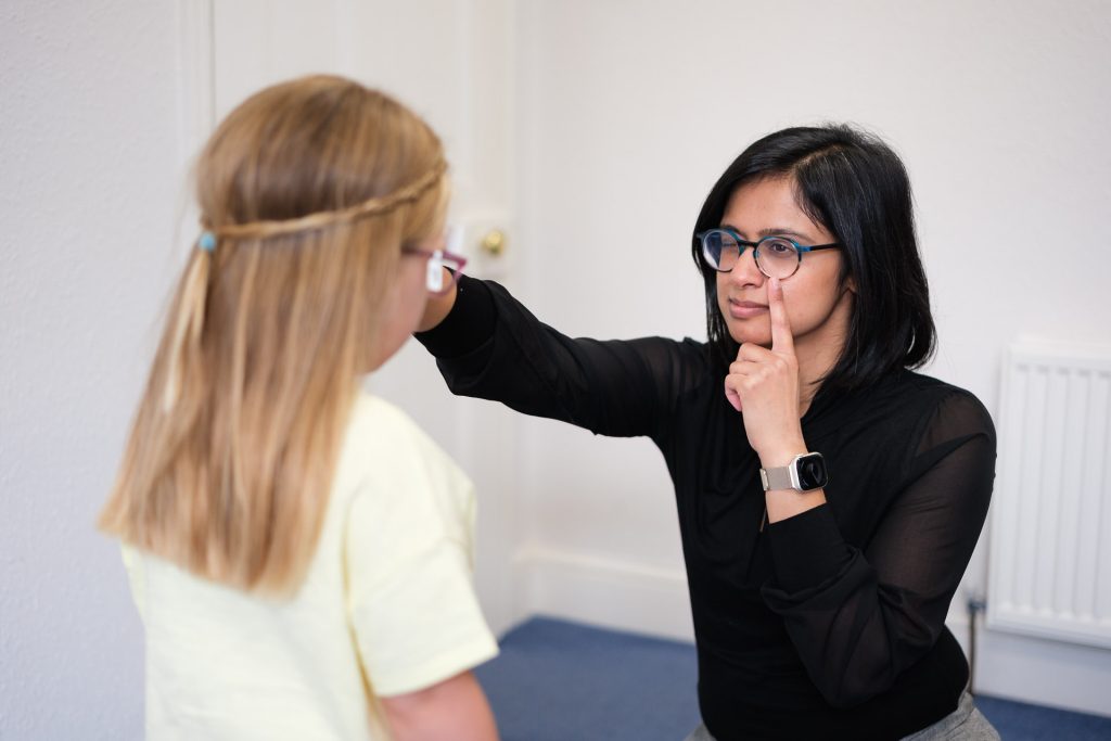 Young girl having an eye test in a brightly lit consulting room