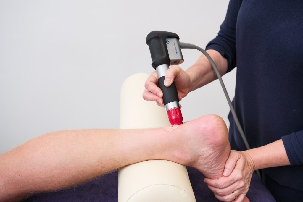 Male client receiving shockwave therapy at The Pure Practice Bath