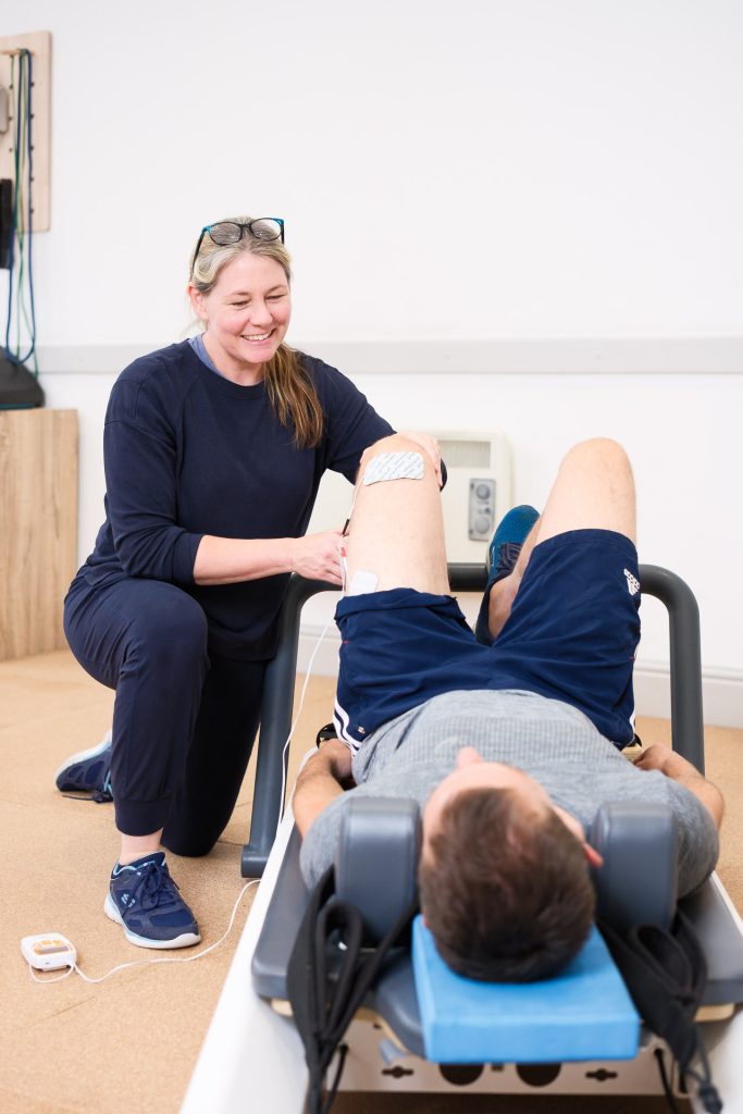 Physiotherapy treatment at The Pure Practice Bath with male client lying on reformer pilates equipment