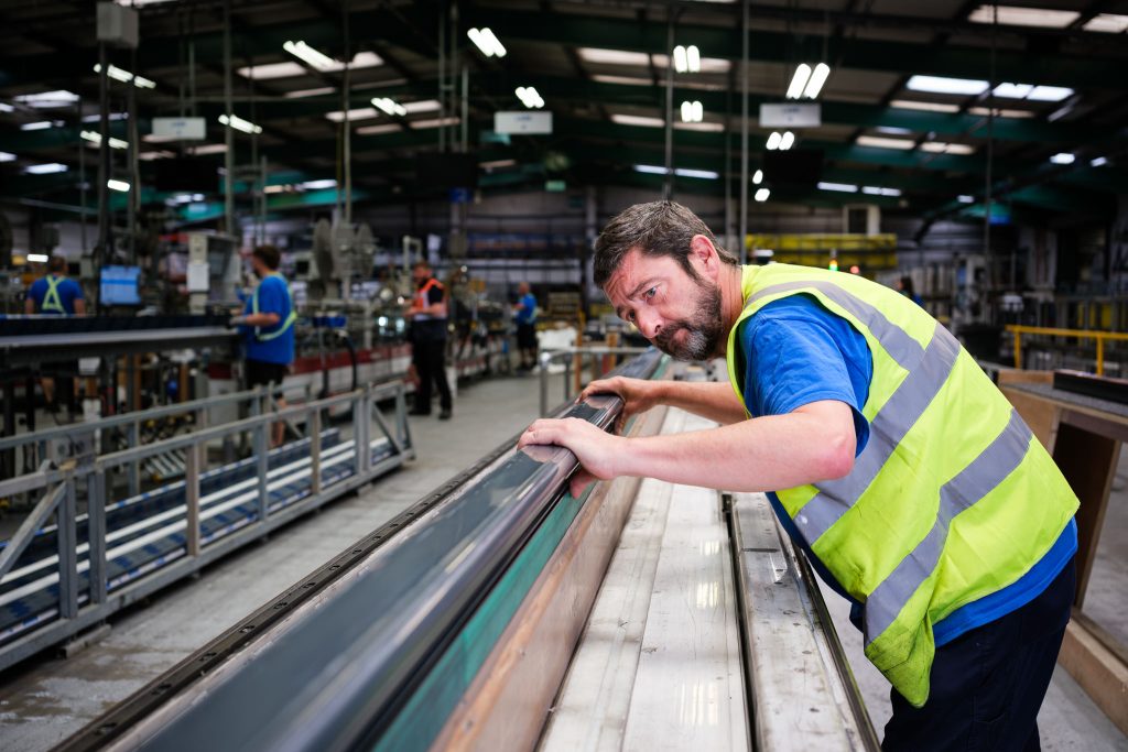 Manufacturing photography showing a skilled line manager monitoring product quality
