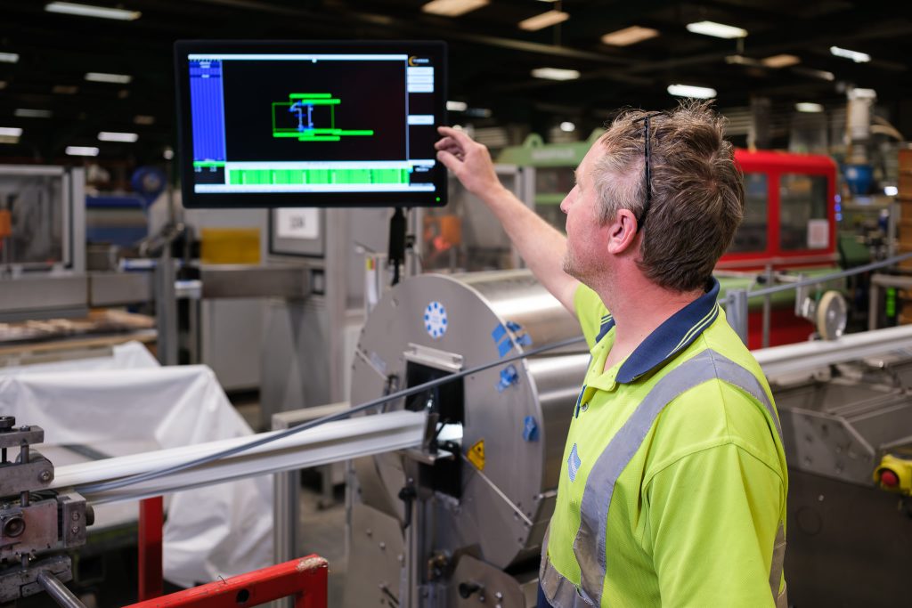 Manufacturing photography showing a line manager setting up a production console on the factory floor