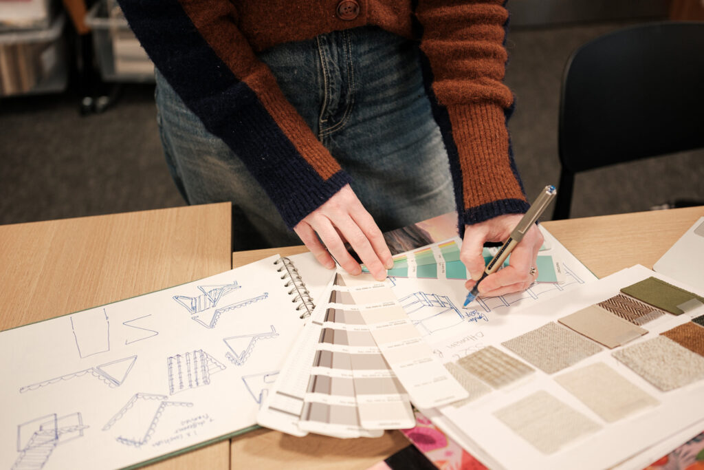 Editorial-style business photography of a Furniturebox designer working on product sketches