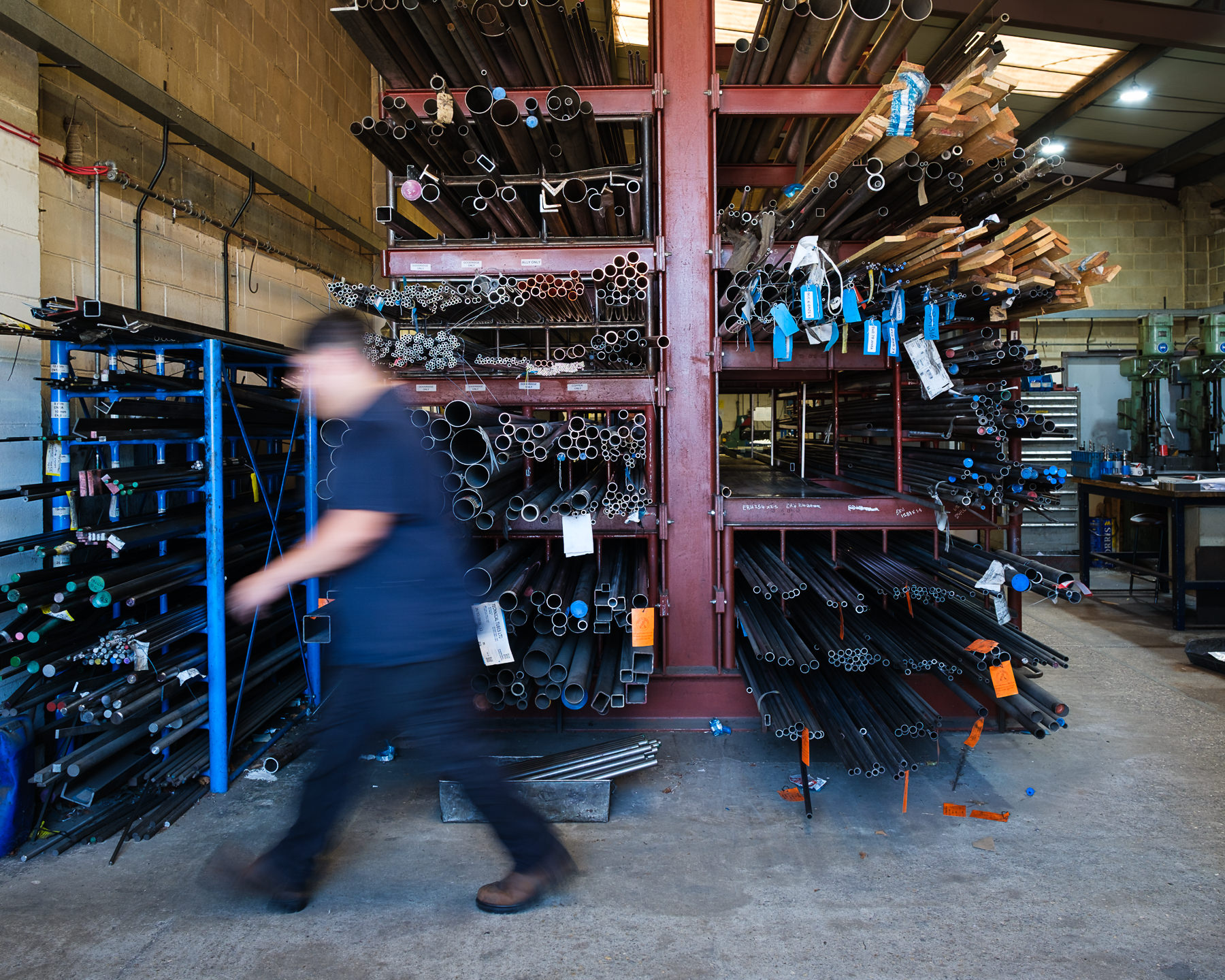 Tube storage racks at Technical Tubes manufacturing facility with slo mo walk of employee