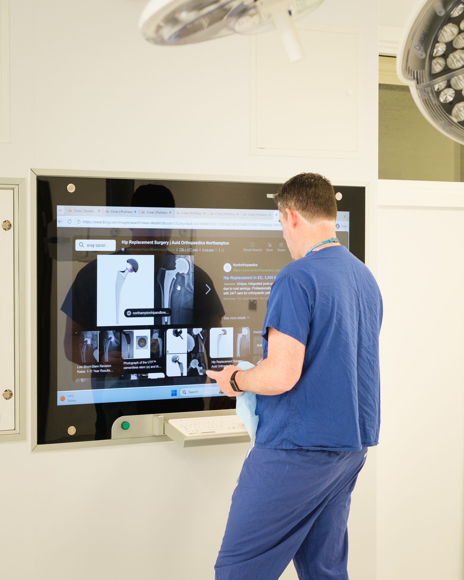 Consultant orthopaedic surgeon James Berwin reviewing medical imaging in a hospital operating theatre.